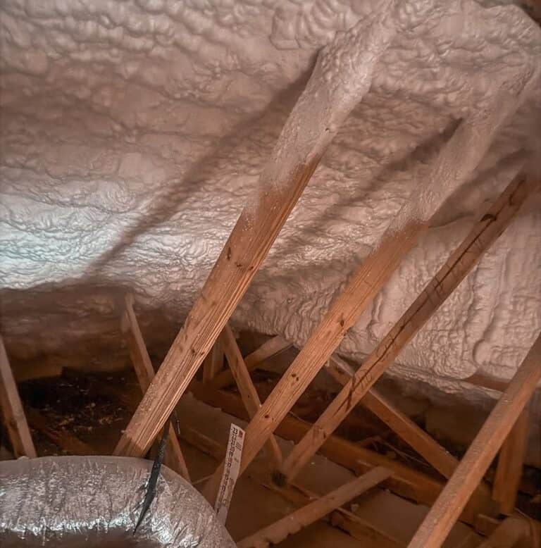 Spray foam on an attic roof deck above flex ductwork