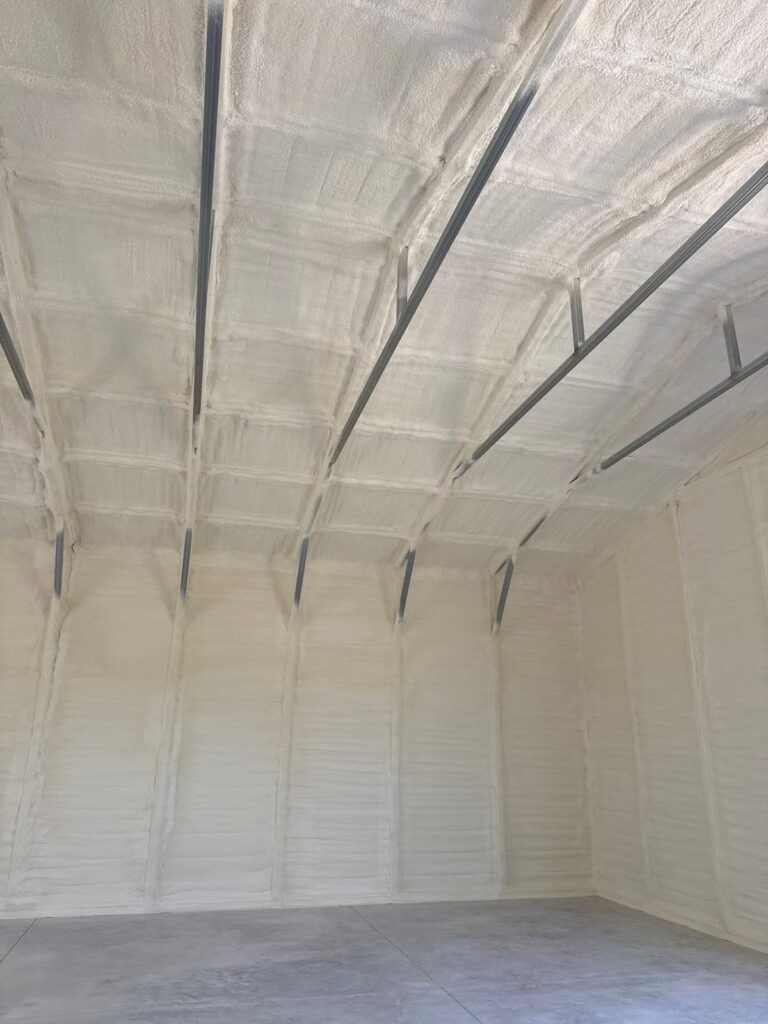 Spray foam insulation on the walls and ceiling of a metal building