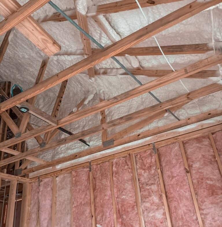 Spray foam roof deck and fiberglass batt walls in a home under construction